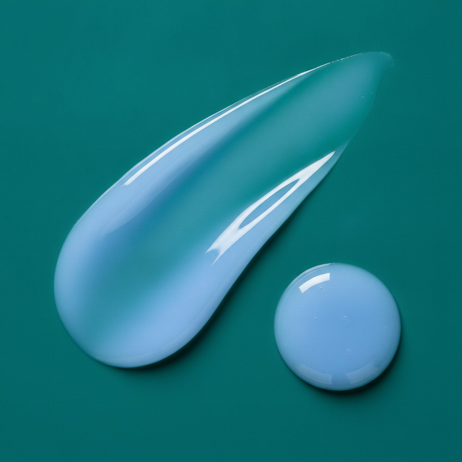 Pale periwinkle Peptide Potion serum drawn from the gold dropper on deep emerald